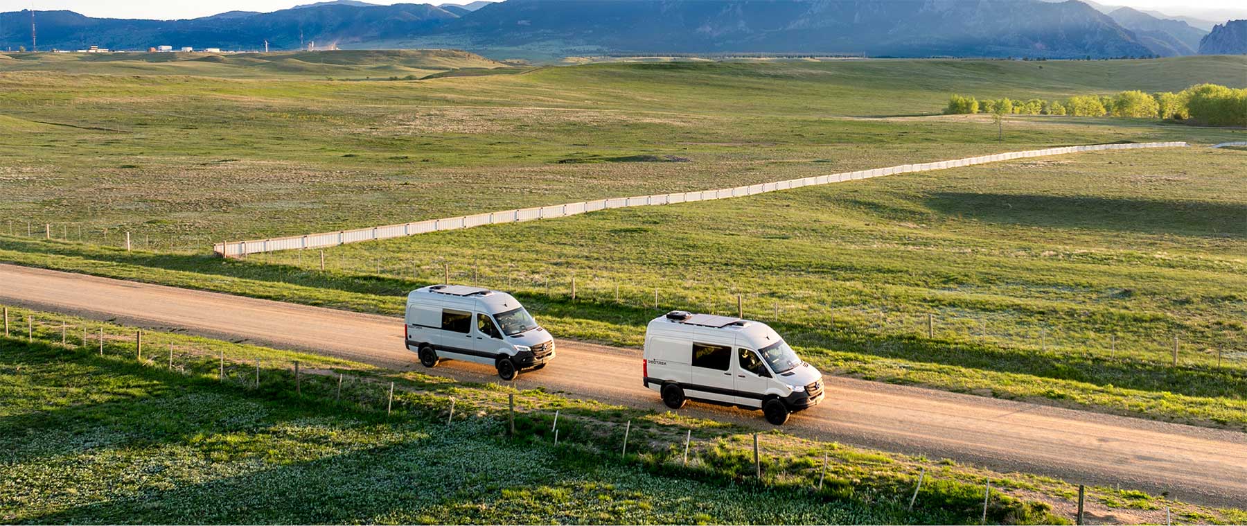 Bear Peak and Flatiron camper van models on a dirt road