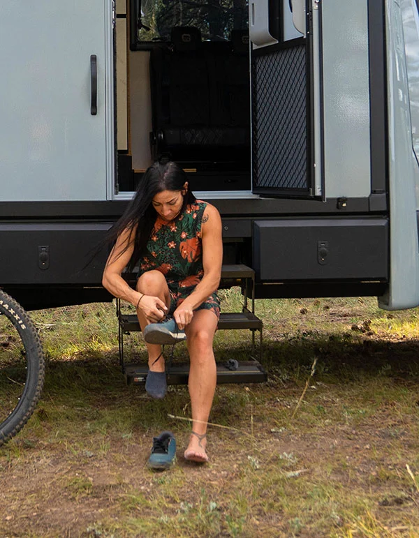 Woman sitting on the electric 3-step entry of a Geotrek Verus putting on her shoes