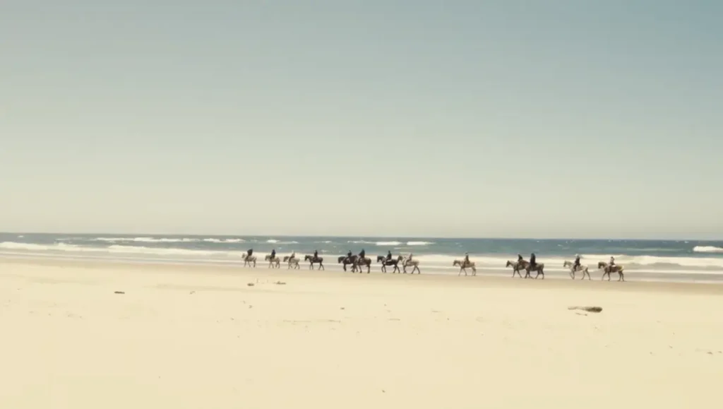 Geotrek meetup attendees riding horses along the Oregon coast beach